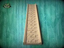 Load image into Gallery viewer, a wooden carving of a series of figures arranged in a vertical line, set against a green background.
