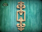 a decorative wooden frame with intricate floral designs, set against a green textured background.