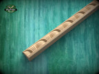 A wooden mold or carving with a curved design is shown against a green textured background.