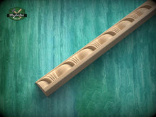 Load image into Gallery viewer, A wooden mold or carving with a curved design is shown against a green textured background.
