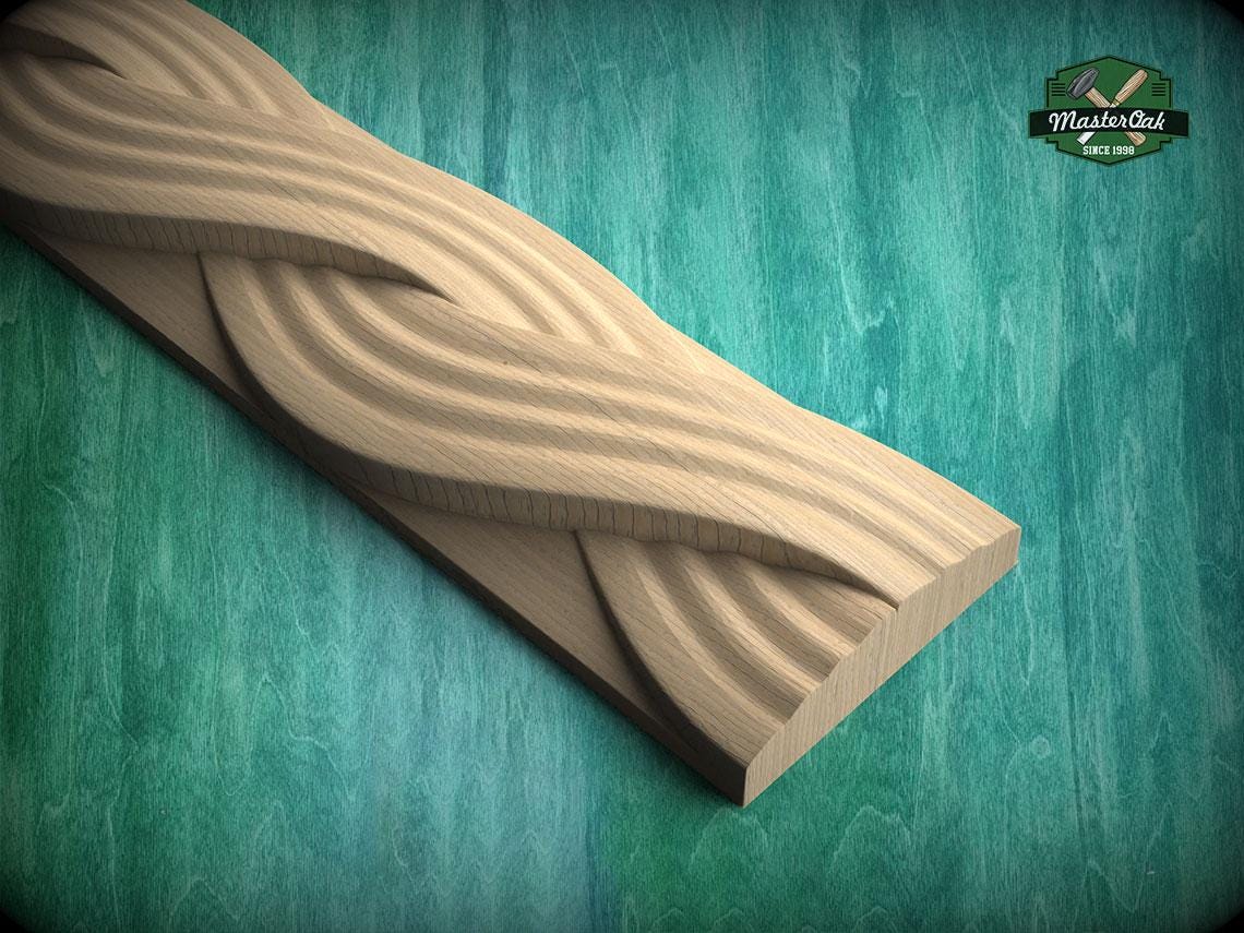 A wooden carving with a curved, wavy design is displayed against a green background.