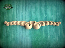 Load image into Gallery viewer, A decorative wooden carving with a swirling, organic design is displayed against a textured green background.

