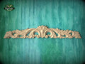 a decorative wooden carving on a green background.