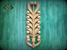 Load image into Gallery viewer, a decorative wooden carving of a stylized tree or plant with intricate scrollwork and shapes, mounted on a green textured background.
