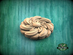 A wooden flower-shaped object is displayed against a green background.