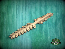 Load image into Gallery viewer, A decorative wooden leaf-like object is displayed against a green textured background.
