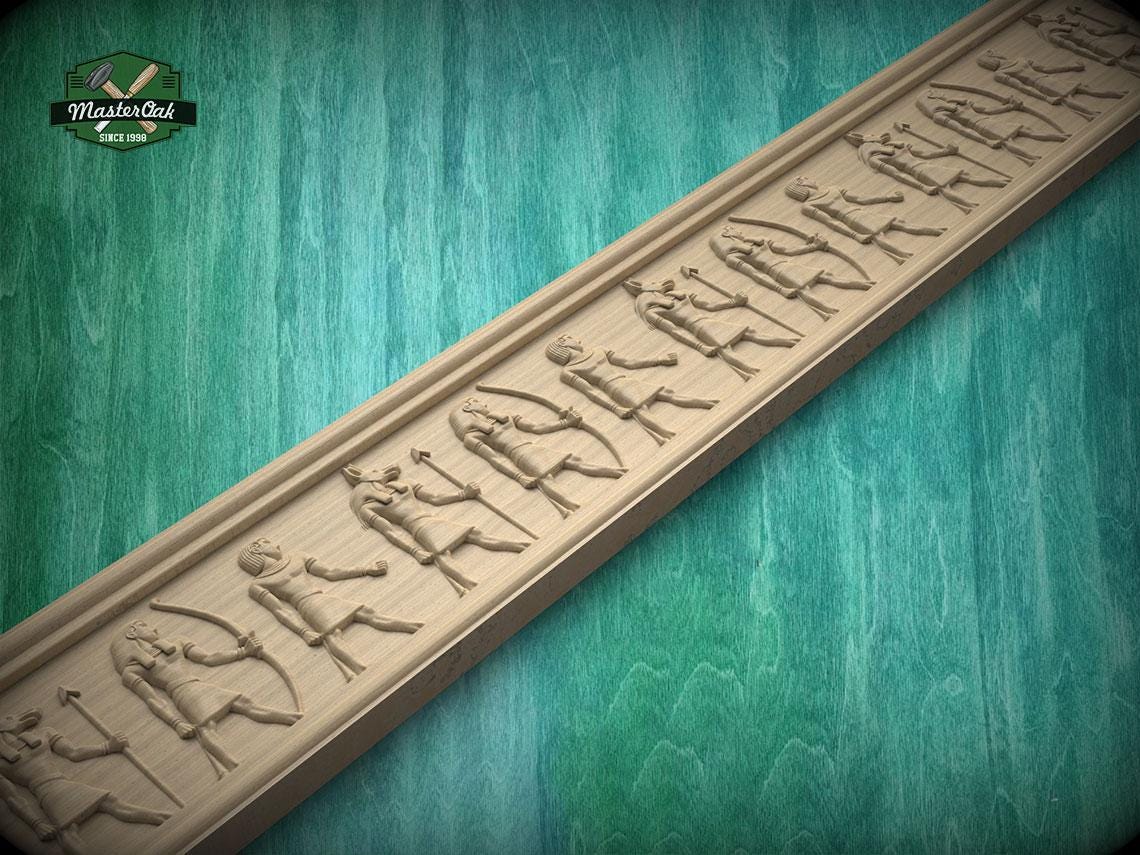 A wooden carving of a row of figures, likely representing a historical or cultural figure, is displayed against a teal-colored background.