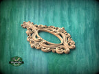 A decorative wooden frame with an ornate, floral design is displayed against a green textured background.
