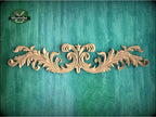 a wood carving of an ornate design on a green background