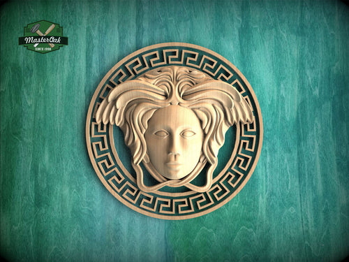 a wooden carving of a woman's face with an ornate design around it, set against a green background.