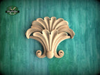 a decorative wooden piece with a floral design, set against a green background.