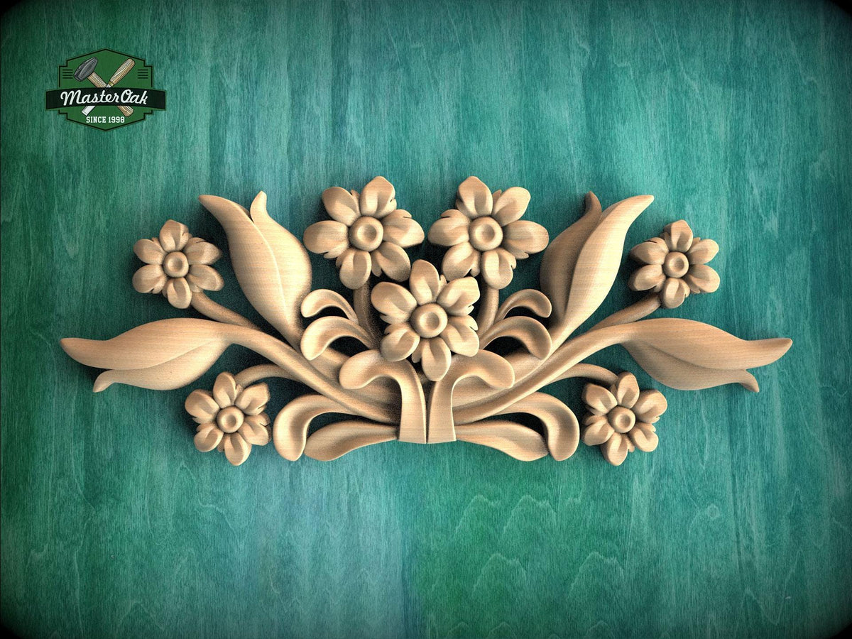 A decorative wooden carving of flowers and leaves on a green background.
