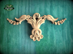 A decorative wooden carving of a flower or plant with intricate, flowing shapes is displayed against a green background.