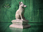 Wood carved fox newel post finial sculpture, natural wood animal statue sitting on a decorative pedestal, displayed on a green wood background