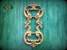 Load image into Gallery viewer, an ornate, carved wooden frame with intricate scrollwork and floral designs, set against a green textured background.
