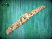 Load image into Gallery viewer, A decorative wooden carving with intricate floral and leaf-like patterns is displayed against a teal-colored background.
