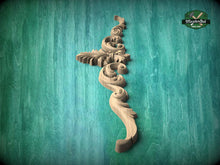 Load image into Gallery viewer, A decorative wooden carving in the shape of a stylized flower or plant is displayed against a teal-colored background.
