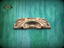 Load image into Gallery viewer, A wooden carving or sculpture is displayed against a green background.
